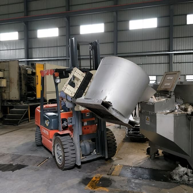 Forklift transferring a large crucible of molten aluminum into a holding furnace inside a die casting factory